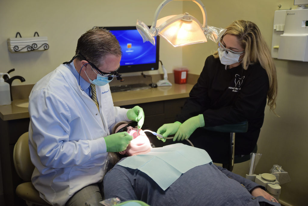 Our periodontist, Dr. Warren, conducts a gum disease screening on a patient. 