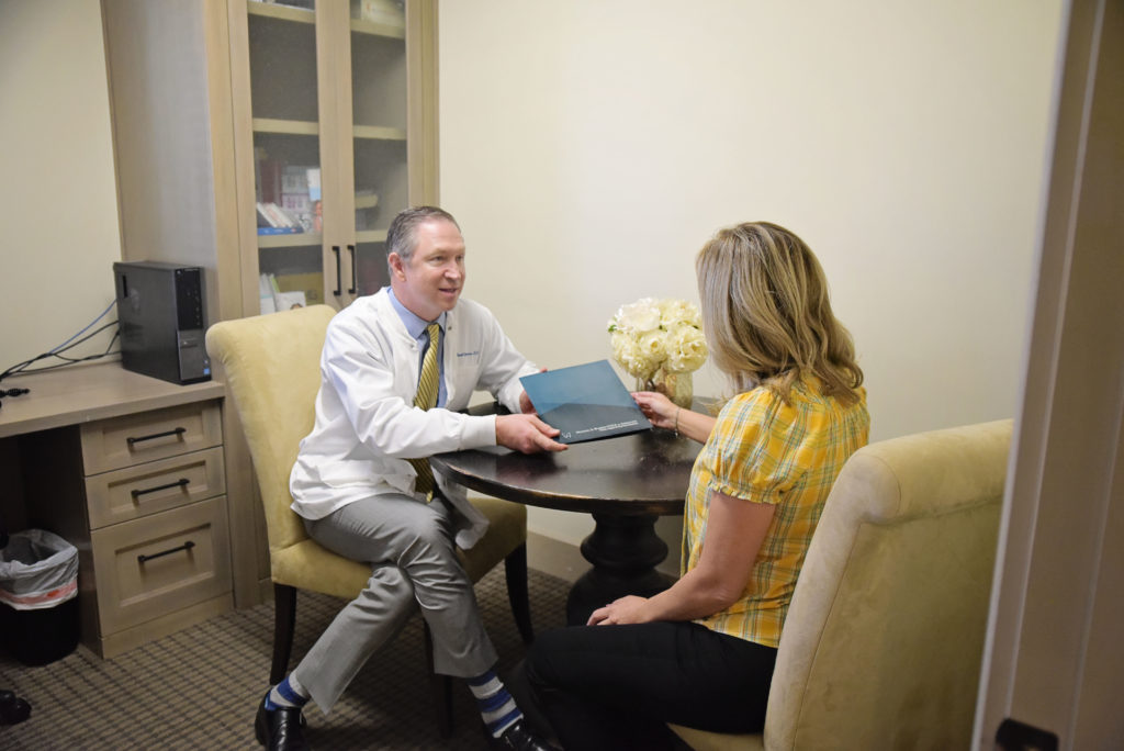 Dr. Warren consults with a patient about how dental veneers can improve her smile.