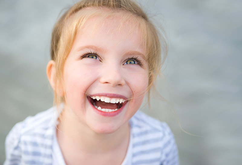 Laughing young girl showing her teeth